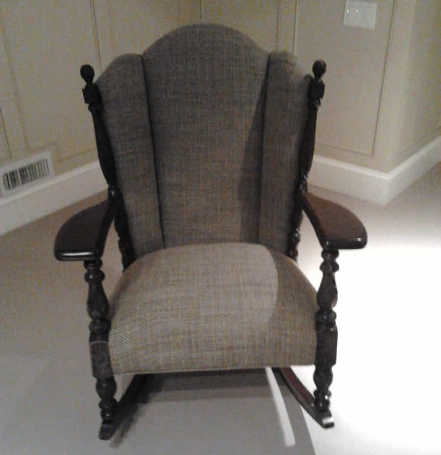 A classic wooden rocking chair with cushioned seat and backrest.